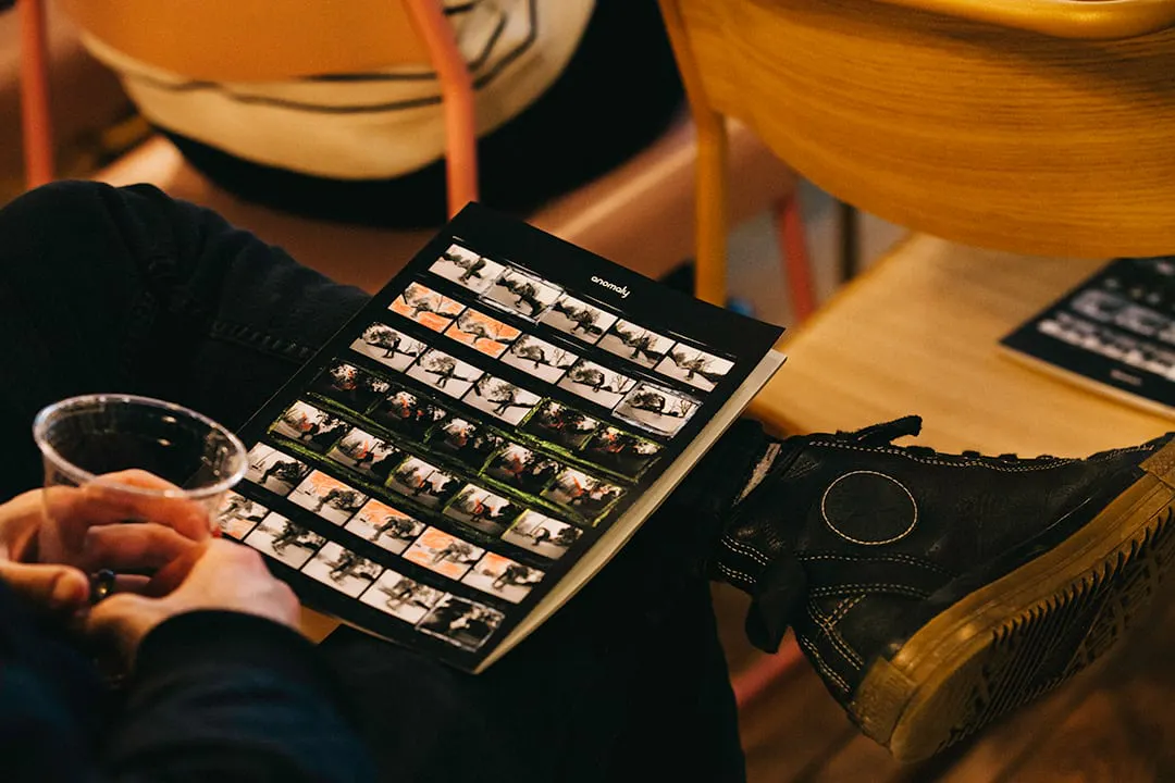 A person sitting with one leg crossed over the other with a custom magazine sitting in their lap.