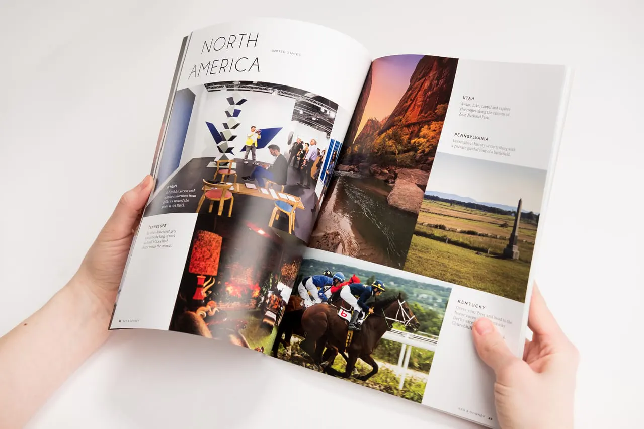 Two hands holding a travel booklet open and printed with North America and various images.