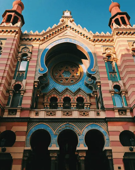 The Jubilee Synagogue in Prague with a red and cream colored design and teal accents.