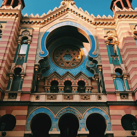 The Jubilee Synagogue in Prague with a red and cream colored design and teal accents.