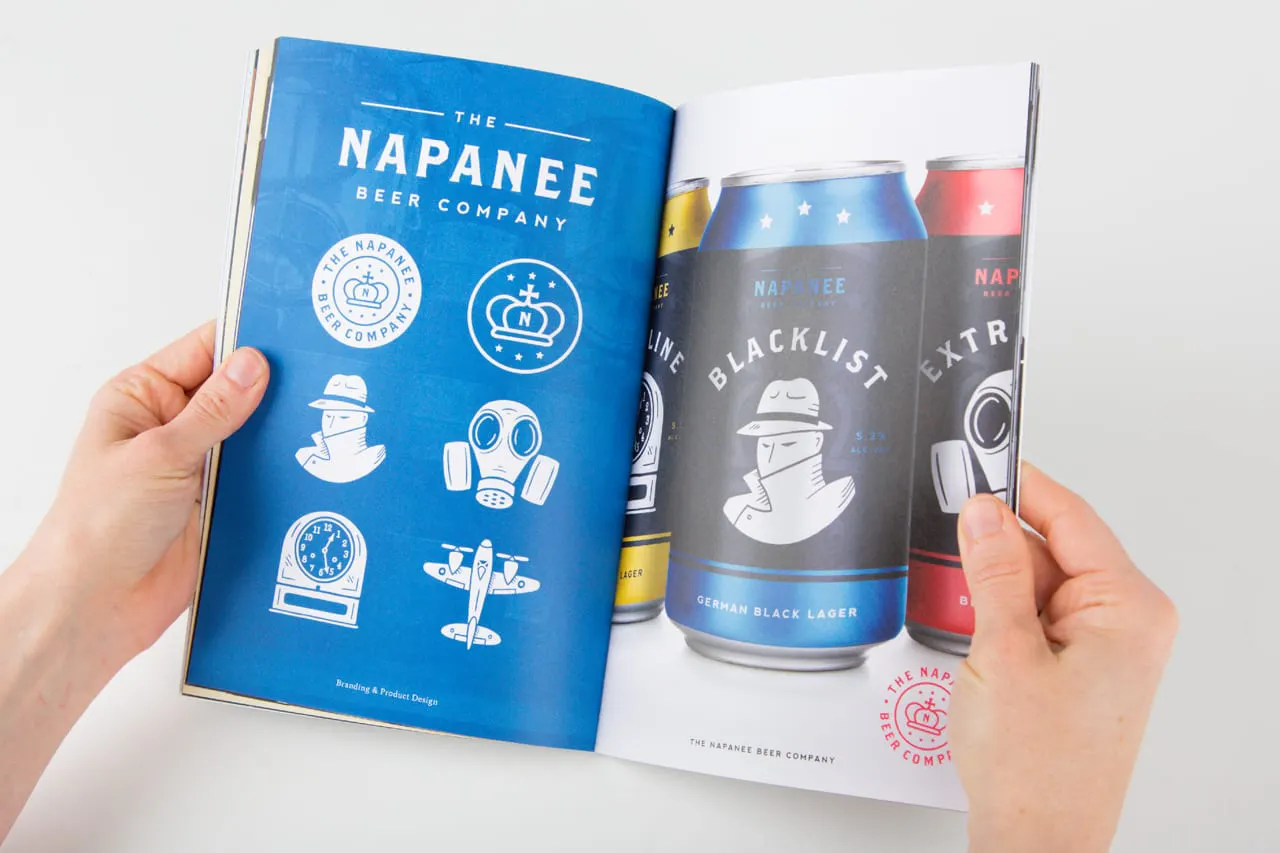 Two hands holding open a portfolio to beer cans with custom illustrations on them.