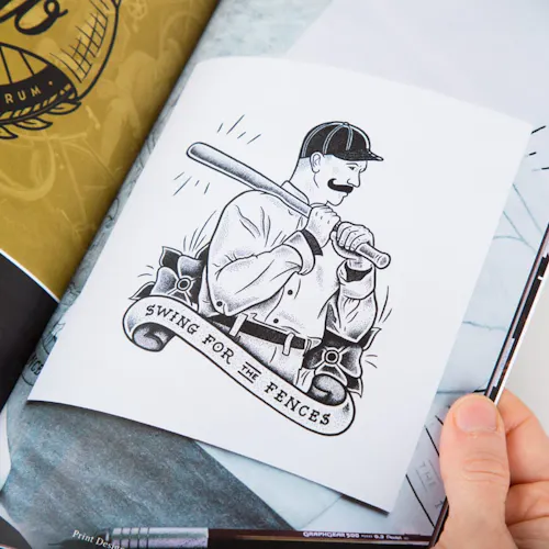 A hand holding open a portfolio book to an illustration of a man holding a baseball.