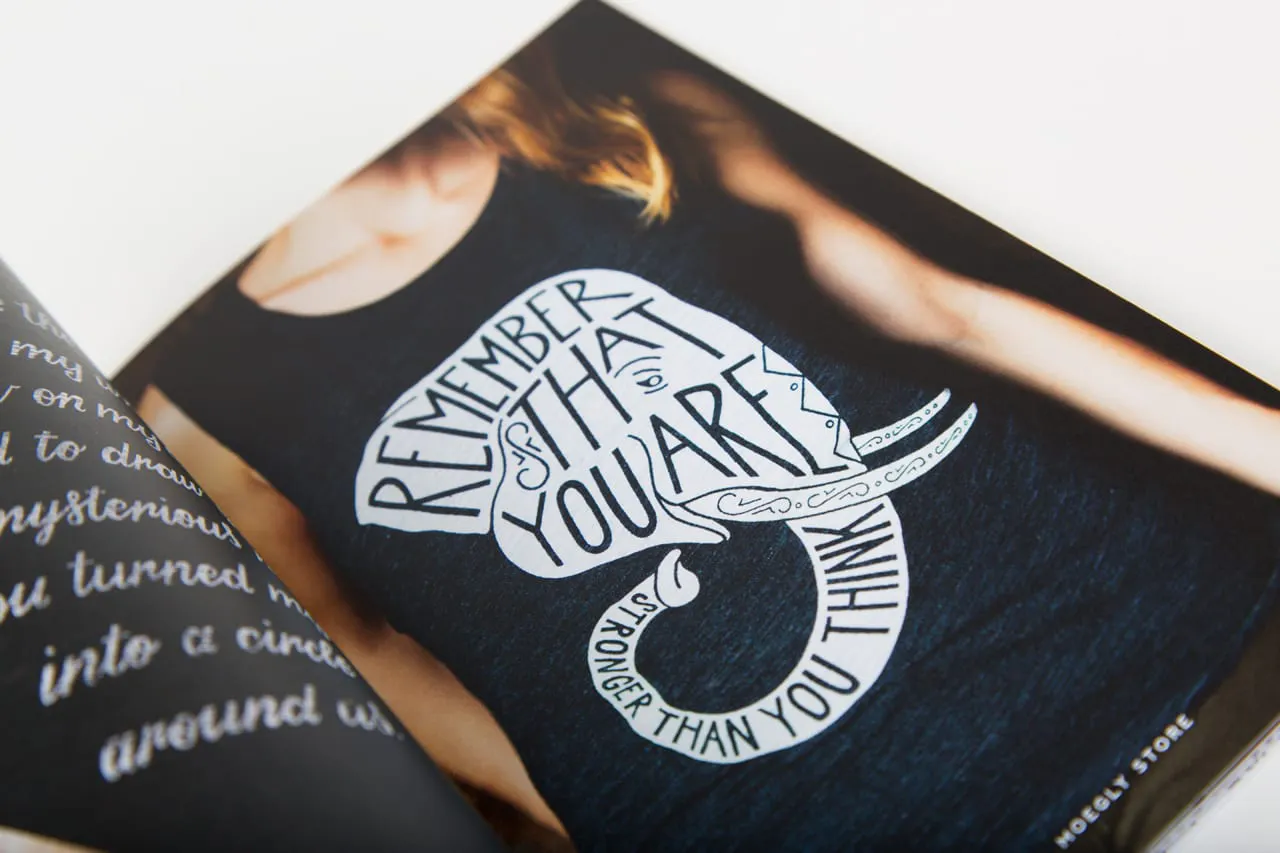 A portfolio book with an image of a girl wearing a black tank top with a custom illustration on it.