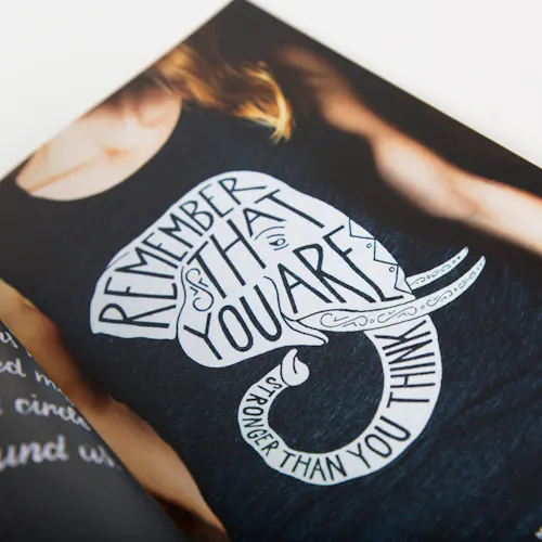 A portfolio book with an image of a girl wearing a black tank top with a custom illustration on it.