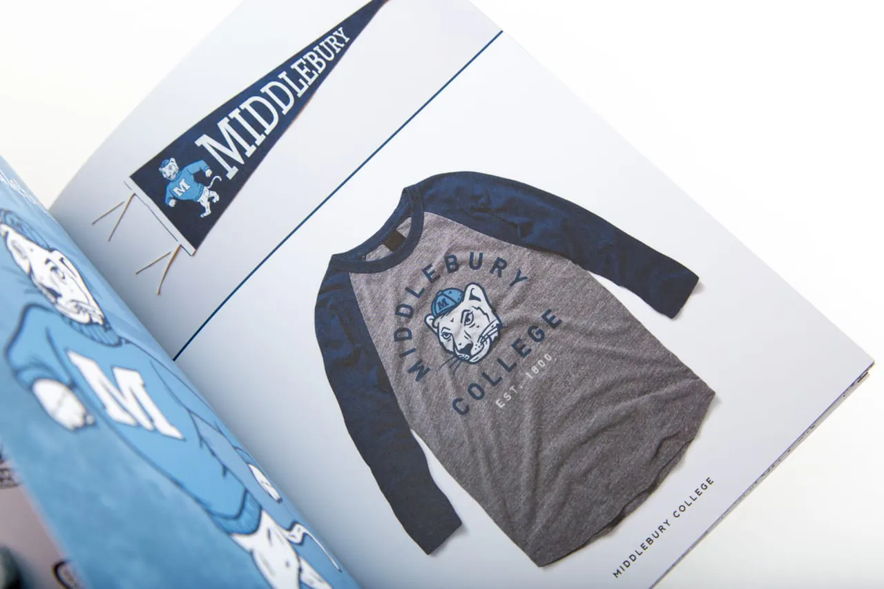 A portfolio laying open to a baseball T-shirt with a custom illustration on it.