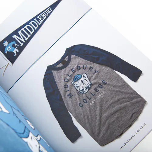 A portfolio laying open to a baseball T-shirt with a custom illustration on it.