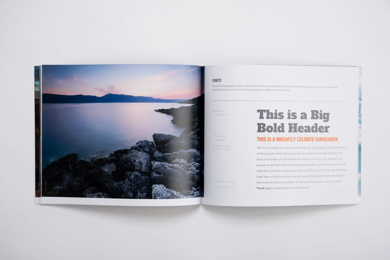 A brand manual laying open to a lake with a rocky shoreline and information about fonts.