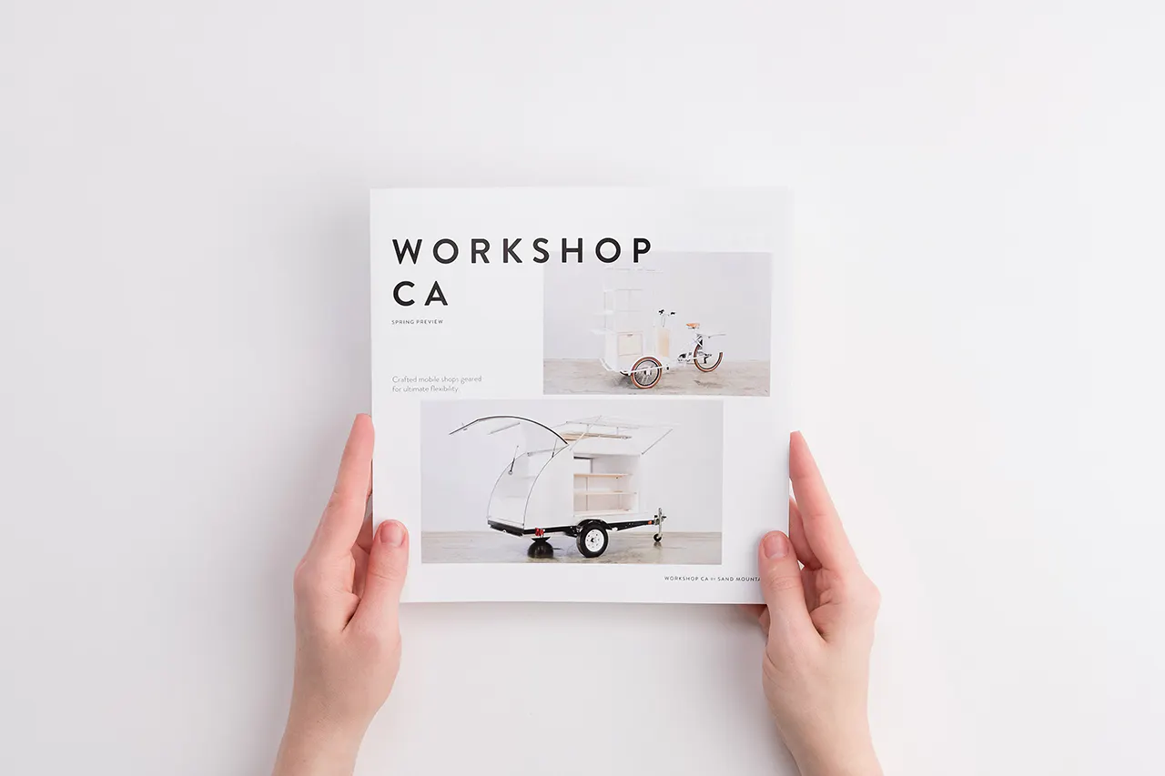 Two hands holding a marketing brochure printed with Workshop CA and images of mobile retail shops on the front.