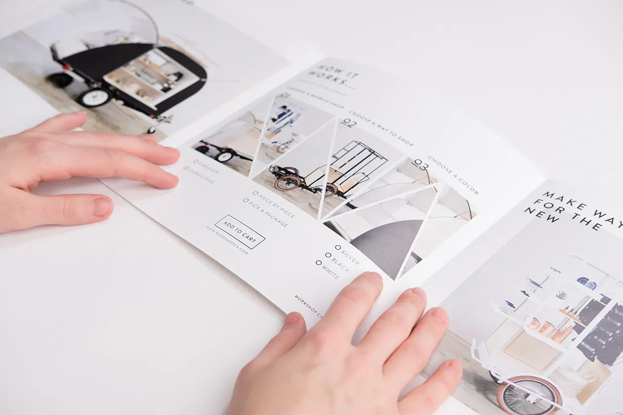 Two hands holding open a tri-fold square brochure with images and details of mobile retails shops.