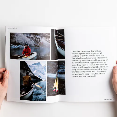 Two hands holding open a visual journal to images of winter canoeing.