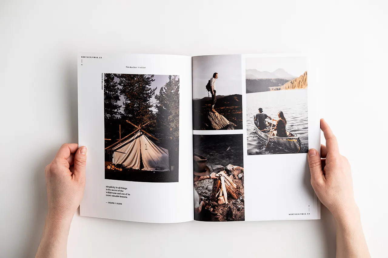Two hands holding open a visual journal to images of camping, canoeing, a fire and a tent.