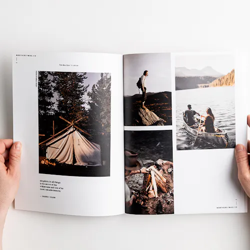Two hands holding open a visual journal to images of camping, canoeing, a fire and a tent.