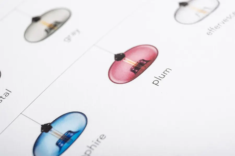 Lamps in blue, pink and clear color displayed in a product catalog.