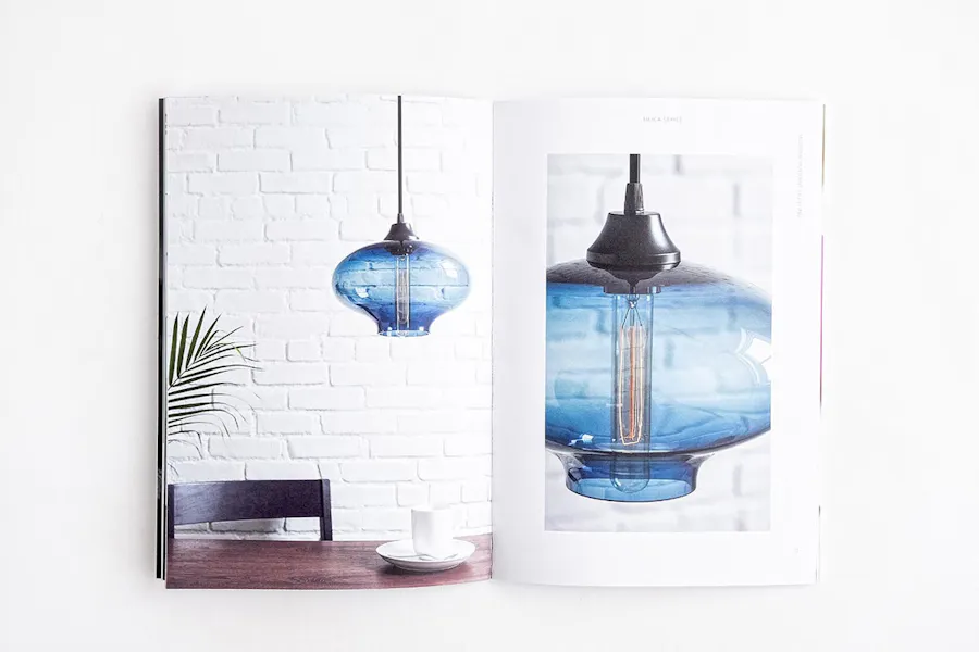 A custom product catalog laying open to a blue lamp on the left and right pages.