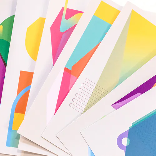 Custom art prints with bright, geometric designs fanned-out in a row.