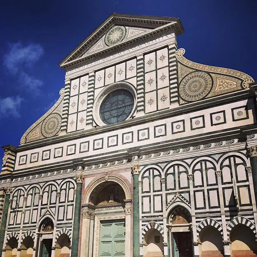 A building in Florence, Italy, with intricate tile work and pale green doors.