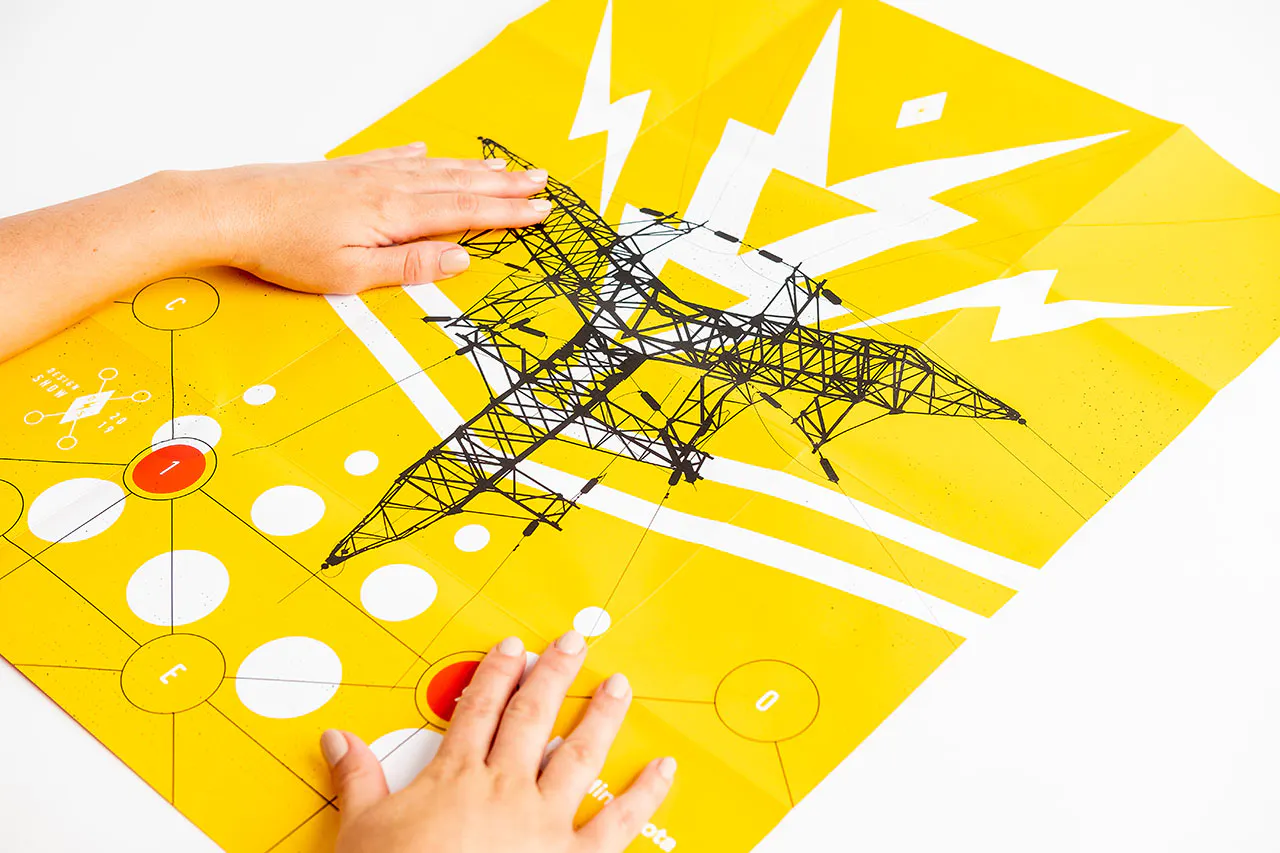 Two hands laying on an unfolded piece of direct mail with a yellow, black and white design.