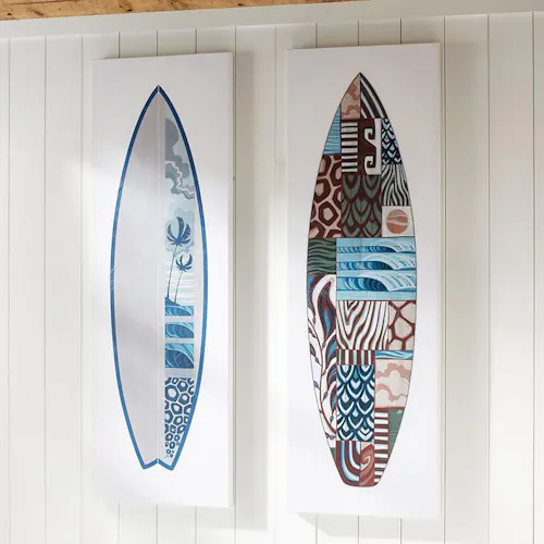 Two custom art prints hanging side by side on a wall with abstract surfboard designs in shades of blue, green and maroon.