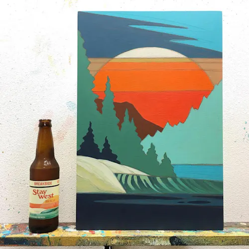 A custom art print with a forest design in shapes of blue, green and orange next to a beer bottle.