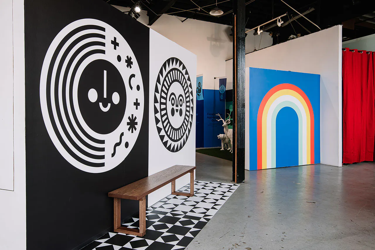 A brown bench sitting in front of a wall with custom decals in black and white on it.