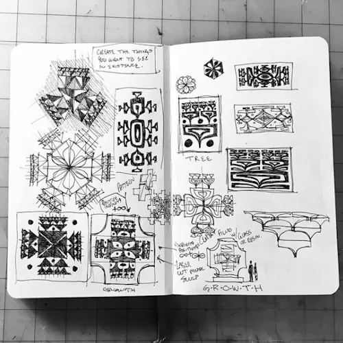 An artist sketchbook laying open to abstract drawings and geometric shapes.