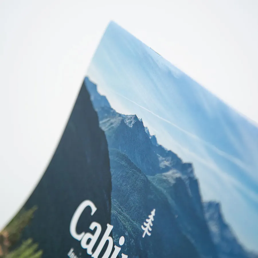 A saddle stitch calendar printed with a mountain scene and Cabin on the cover.