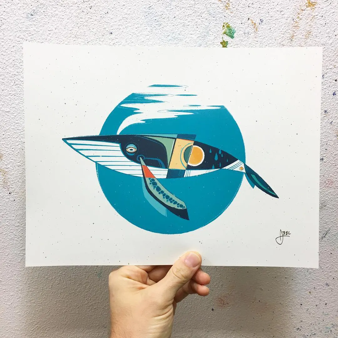 A hand holding an art print with a whale design in shades of blue, green, yellow and orange.