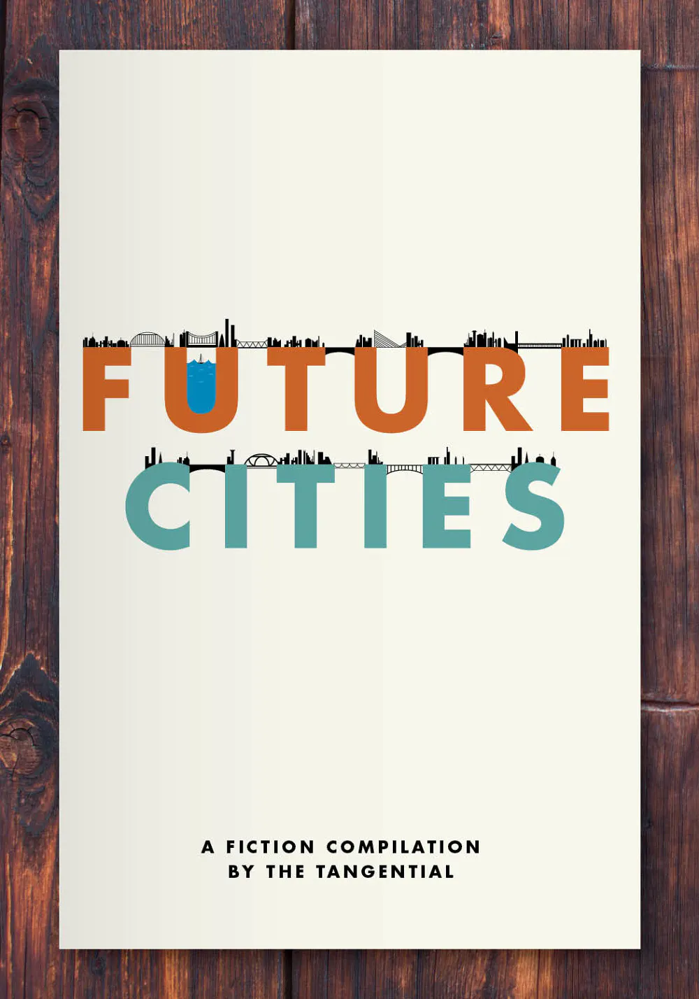 A custom book printed with Future Cities in orange and teal and A Fiction Compilation in black at the bottom.