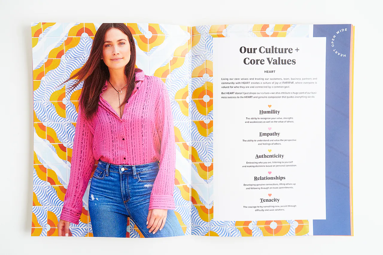 An Evereve brand book laying open to an image of a woman in a pink top and Our Culture + Core Values in black.
