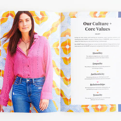 An Evereve brand book laying open to an image of a woman in a pink top and Our Culture + Core Values in black.