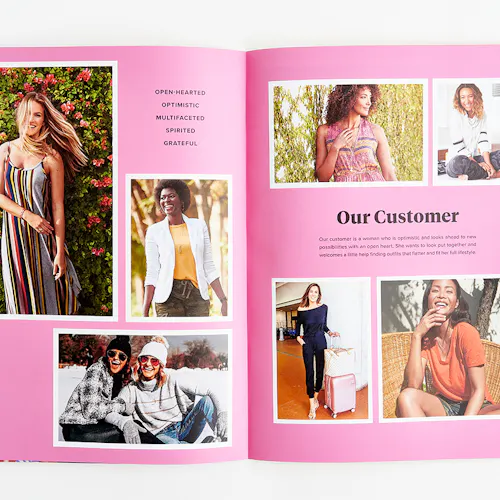 An Evereve brand book laying open to images of smiling women against a bright pink background.