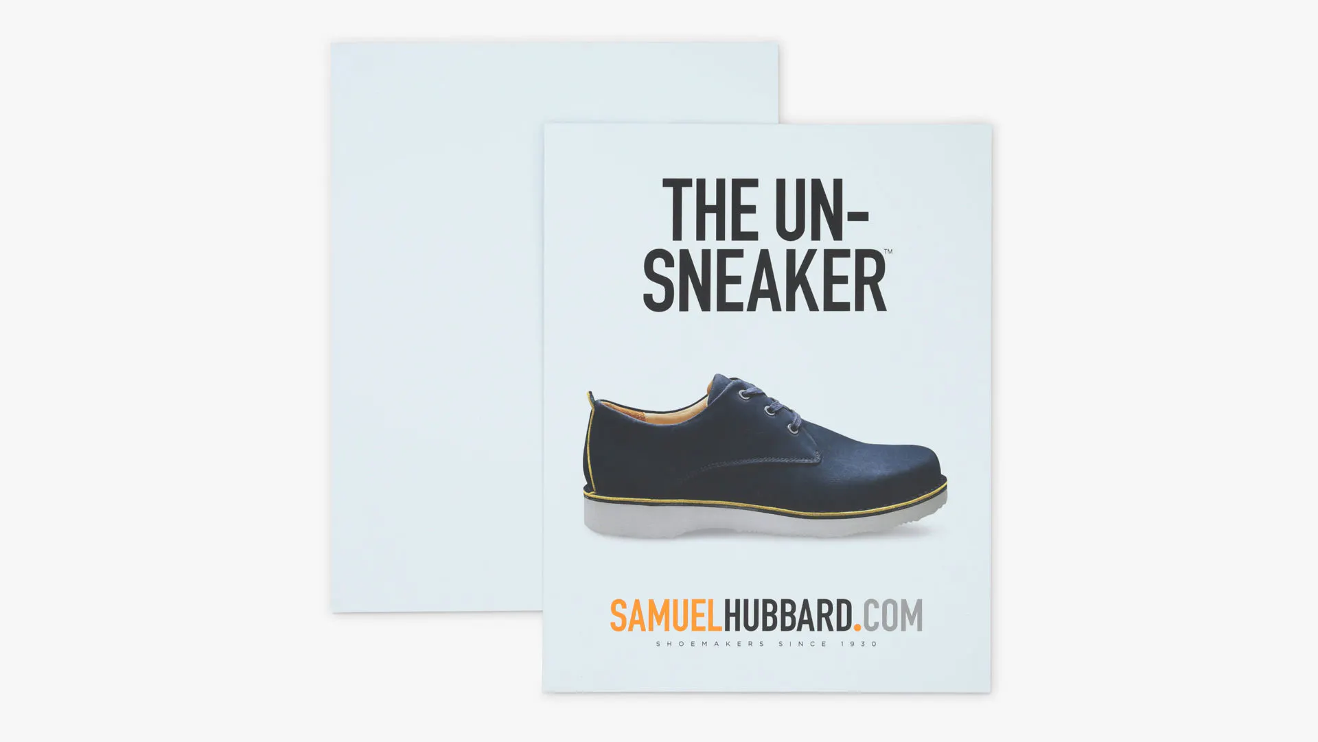 A custom styrene sign printed with The Un-Sneaker and an image of a black shoe with a white sole.