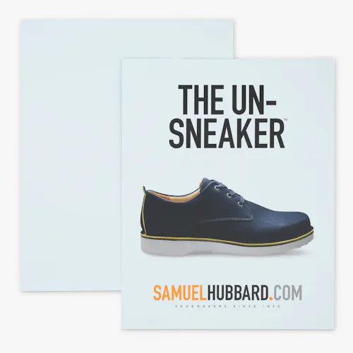 A custom styrene sign printed with The Un-Sneaker and an image of a black shoe with a white sole.
