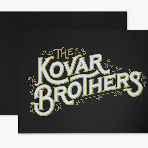 A PVC foam sign custom printed with The Kovar Brothers in gold and white on a black background.