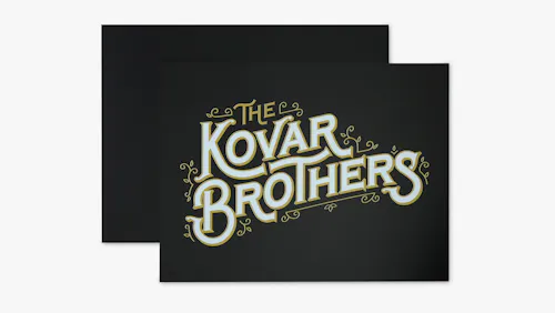 A PVC foam sign custom printed with The Kovar Brothers in gold and white on a black background.