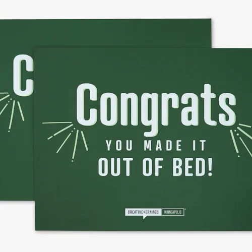 A polystyrene foam sign printed with a green background and Congrats You Made it Out of Bed! in white.