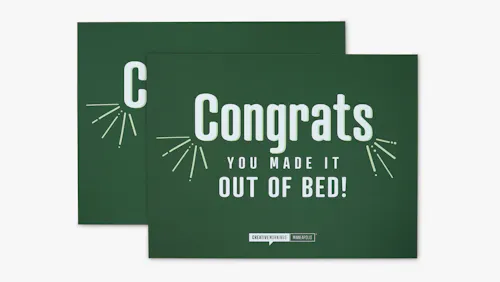 A polystyrene foam sign printed with a green background and Congrats You Made it Out of Bed! in white.