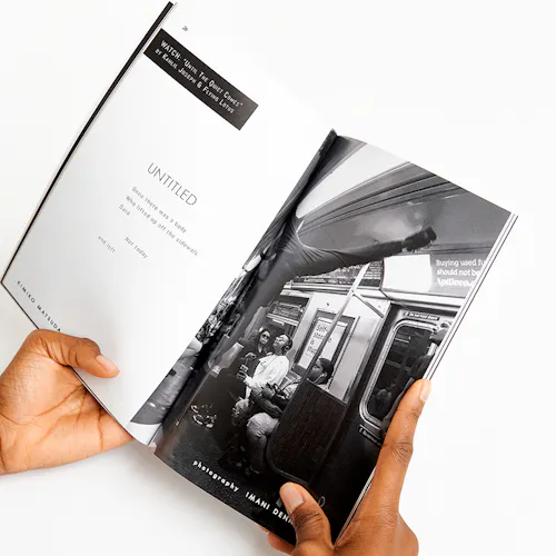 Two hands holding a magazine open to a black and white images of people in a subway car.