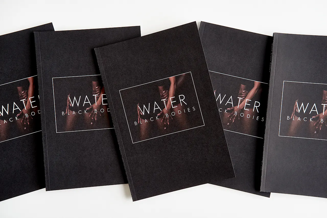 Three custom magazines lined up in a row with black covers and printed with Water Black Bodies on the cover.
