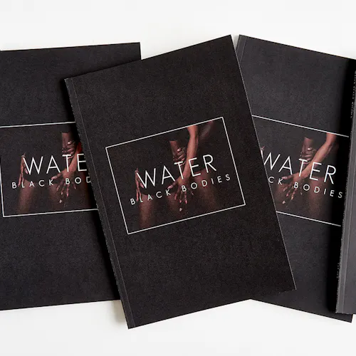 Three custom magazines lined up in a row with black covers and printed with Water Black Bodies on the cover.