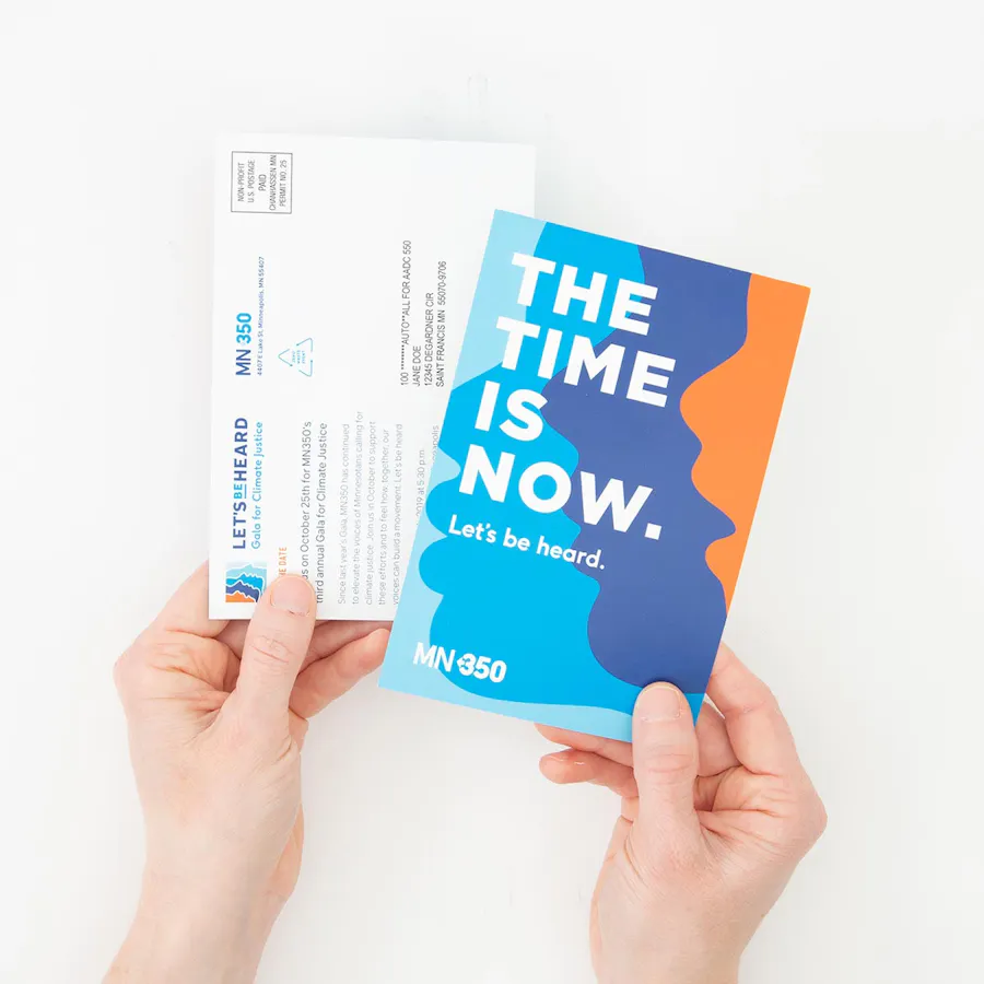 Two hands holding two pieces of direct mail, with The Time is Now on the front.