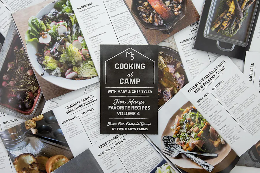Custom recipe booklets overlapping each other and laying open to food images and instructions.