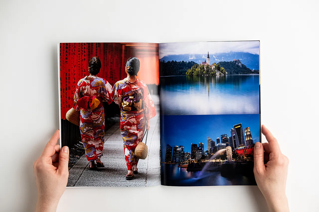 A photography book laying open to images of two Asian woman in floral outfits, a city at night and a castle.