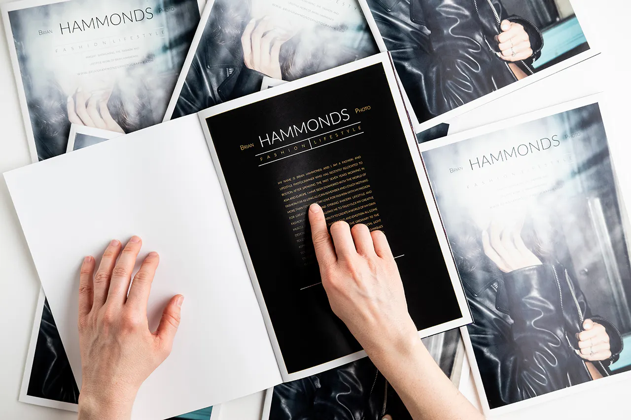 Two hands holding open a photography portfolio printed with Brian Hammonds Photo Fashion Lifestyle.