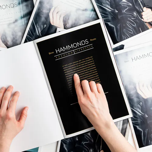 Two hands holding open a photography portfolio printed with Brian Hammonds Photo Fashion Lifestyle.