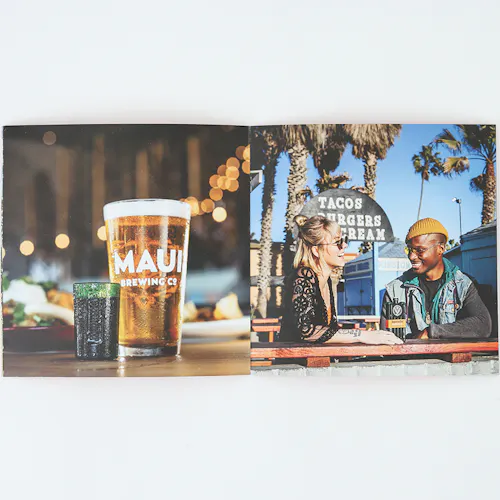 ©Will Strawser A photo book laying open to images of a pint glass of beer and two people sitting at a table outside.