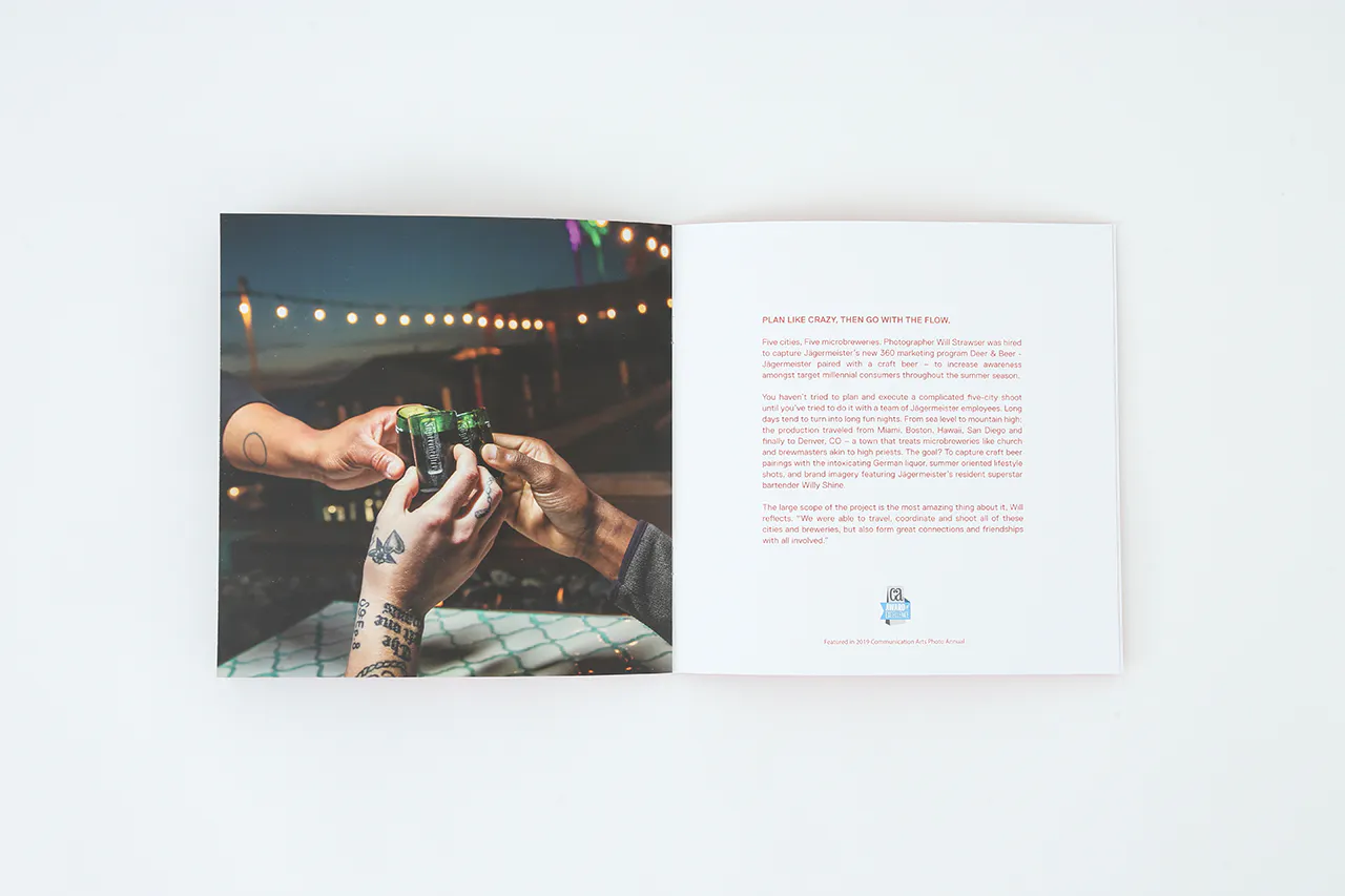 A portfolio printed with an image of three hands toasting with shot glasses and details printed in red.