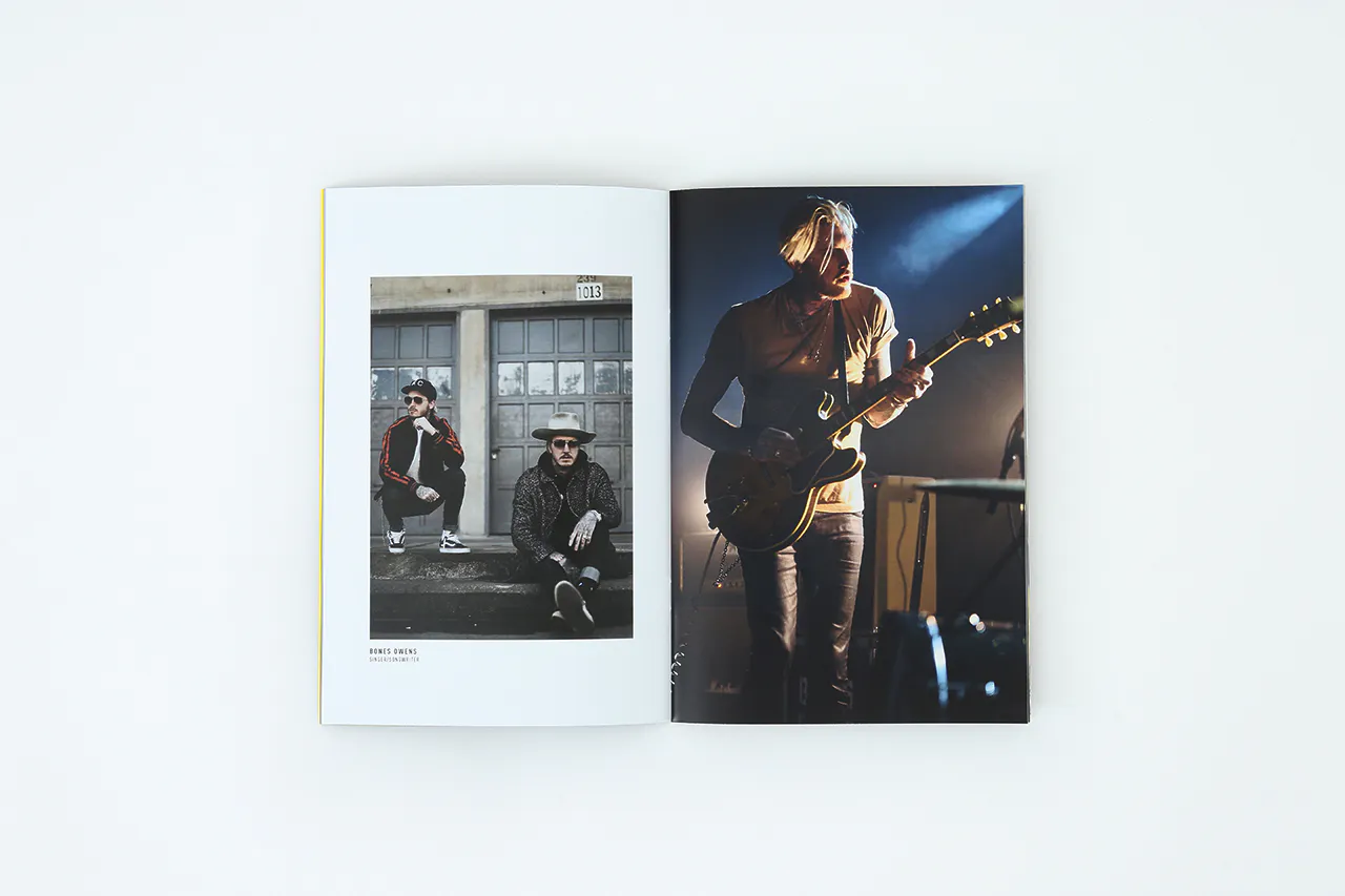 A portfolio laying open to images of a man playing guitar and two men sitting in front of a garage door.