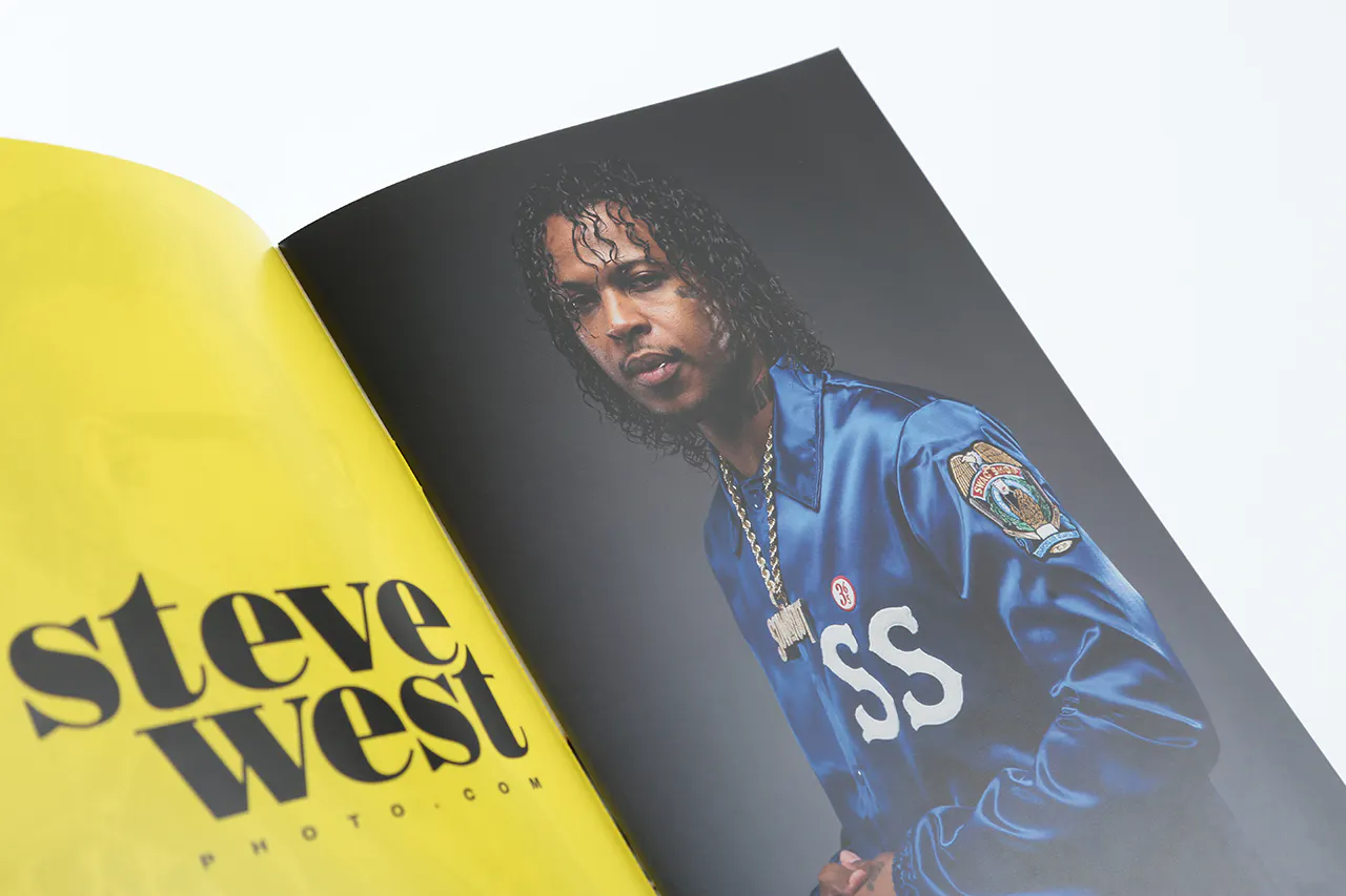 A photography booklet laying open to an image of a man in a blue jacket and Steve West on a yellow background.