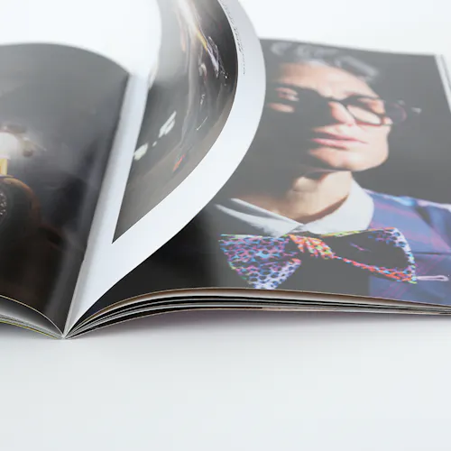 A photography portfolio laying open to images of a person wearing glasses and a bowtie.